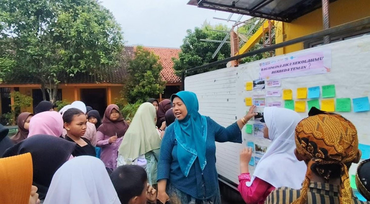  SD 01 Gebangsari pupils together with their teacher discuss their dream schoolyard as part of a co-design process. (Courtesy of Milklife)

