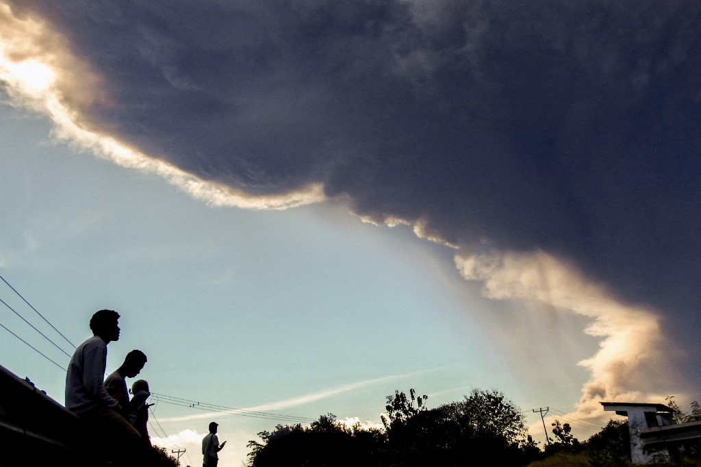 Villagers observe Mount Lewotobi Laki-laki as it erupts, as seen from Nangahale village in Sikka, East Nusa Tenggara on July 7, 2025. 
