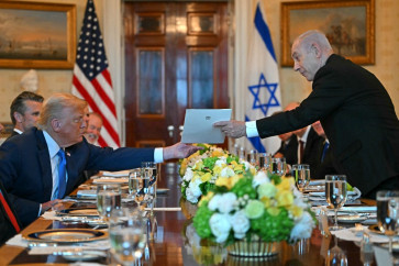 Israeli Prime Minister Benjamin Netanyahu (right) hands over a letter to US President Donald Trump as they meets at the Blue Room of the White House in Washington, DC, on July 7, 2025. 