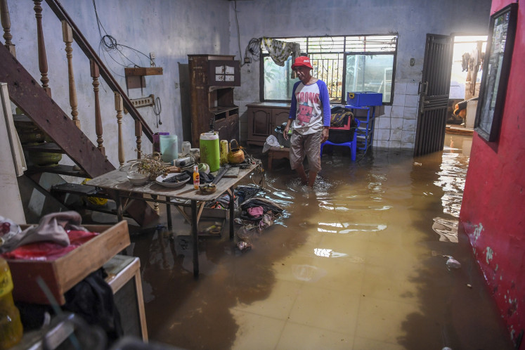 A man checks on his flooded house in Cililitan, East Jakarta, on July 8, 2025. The Jakarta Disaster Mitigation Agency (BPBD) recorded 62 neighborhood units (RT) across the city flooded as of July 8.