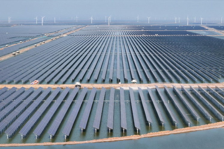 Solar panels and wind turbines are seen at the Huaneng Binzhou new energy power generation project in Binzhou, in China's eastern Shandong province on June 11, 2025.