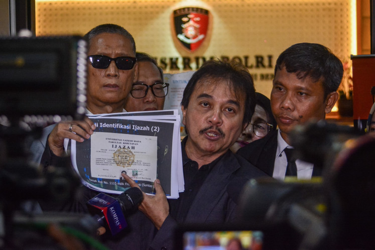 Telematics expert Roy Suryo (center) talks to journalists at the National Police's Criminal Investigation Department (Bareskrim) headquarters in Jakarta on July 9, after attending a case review pertaining to the authenticity of former president Joko “Jokowi“ Widodo's university diploma.
