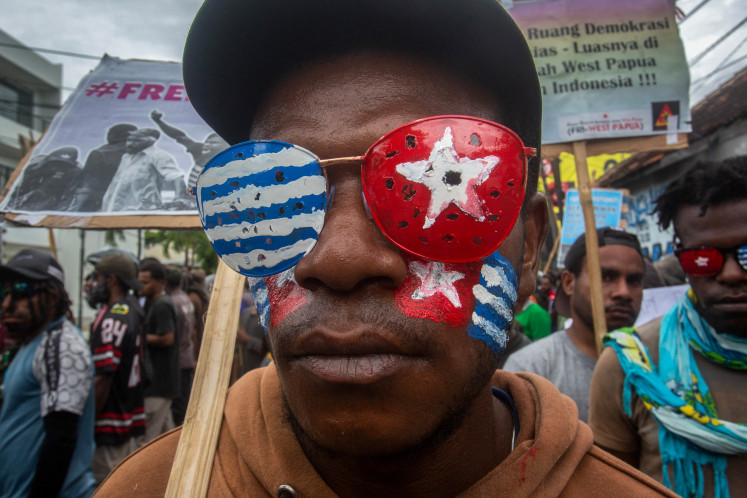 A man wears glasses painted to resemble the banned Morning Star flag of West Papua on Dec. 1, 2024, during a student-led demonstration in Yogyakarta calling for the province’s independence.