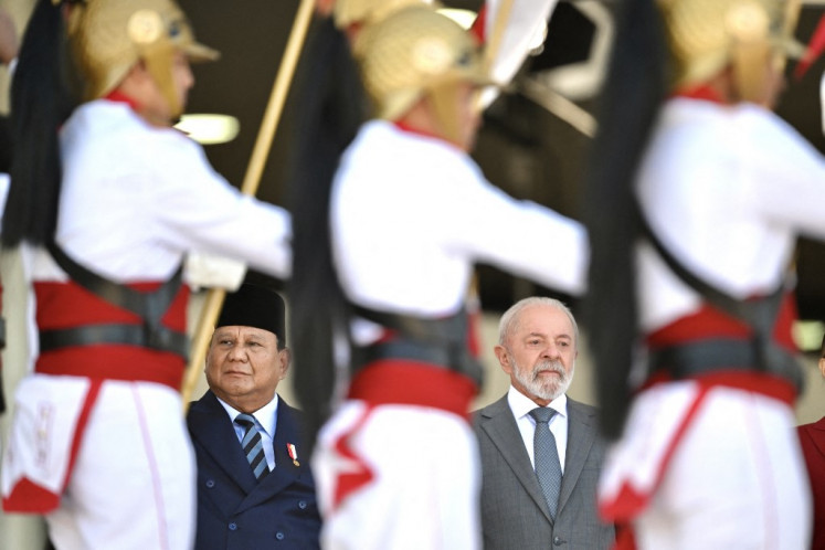 Indonesia's President Prabowo Subianto (left) and Brazil's President Luiz Inacio Lula da Silva listen to their national anthems during a welcome ceremony at Planalto Palace in Brasilia, on July 9, 2025.