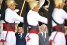 President Prabowo Subianto (left) and Brazil's President Luiz Inacio Lula da Silva listen to their national anthems on July 9, 2025, during a welcome ceremony at Planalto Palace in Brasilia.