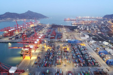 Containers and cargo vessels are seen at sunset at a port in Lianyungang, Jiangsu province, China. Indonesia recorded the biggest trade surplus in nine years in July as exports rose for the third consecutive month while demand for imports remained weak amid the pandemic. 