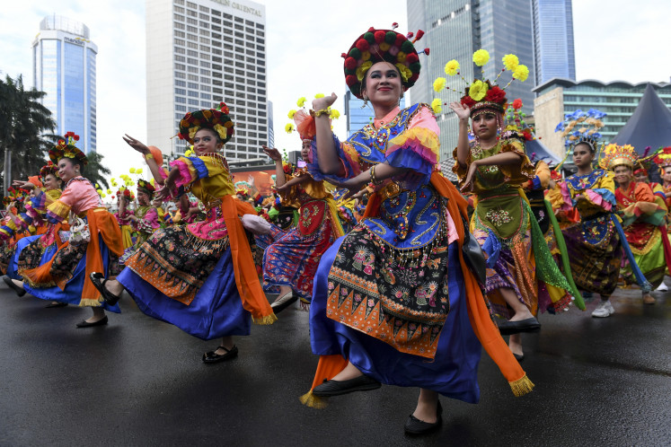 A number of dancers perform a Betawi dance during a large-scale cultural show on Car-Free Day at the Hotel Indonesia traffic circle, Central Jakarta, on July 6, 2025. The cultural performance, themed Jakarta in Color, featured thousands of traditional dancers and martial artists, held to promote and preserve Betawi cultural heritage.