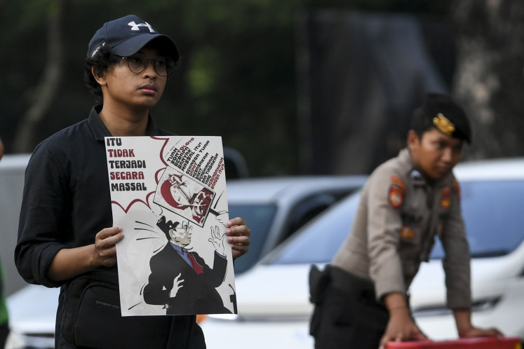 Louder than words: An activist holds a poster criticizing Culture Minister Fadli Zon's statement denying the 1998 mass rapes during a Kamisan (Thursday) silent protest on June 26 in front of the State Palace in Jakarta.