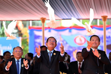 Cambodian President of the Senate and President of Cambodian People's Party (CPP) Hun Sen (center), Cambodia's Prime Minister Hun Manet (right) and Honorary President of the Cambodian People's Party (CPP) Heng Samrin (left) release doves during a ceremony marking the 74th founding anniversary of the Cambodian People's Party (CPP) in Phnom Penh on June 28, 2025. 