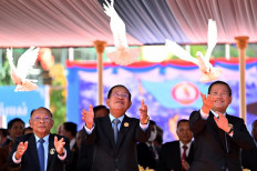 Cambodian President of the Senate and President of Cambodian People's Party (CPP) Hun Sen (center), Cambodia's Prime Minister Hun Manet (right) and Honorary President of the Cambodian People's Party (CPP) Heng Samrin (left) release doves during a ceremony marking the 74th founding anniversary of the Cambodian People's Party (CPP) in Phnom Penh on June 28, 2025. 