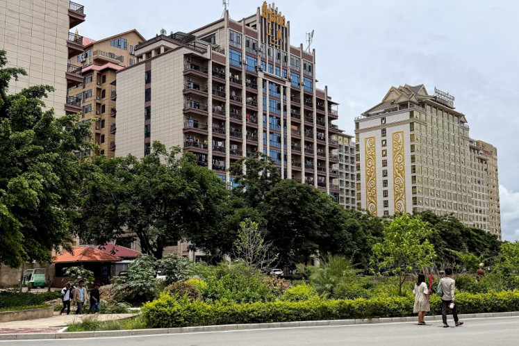 This photo taken on May 26, 2025 shows clothes hanging on balconies of a building inside the Golden Triangle Special Economic Zone along the Mekong river in the Bokeo province of Laos. Rising from the muddy fields on the Mekong riverbank in Laos, a lotus tops a casino in a sprawling city which analysts decry as a center for cybercrime. 