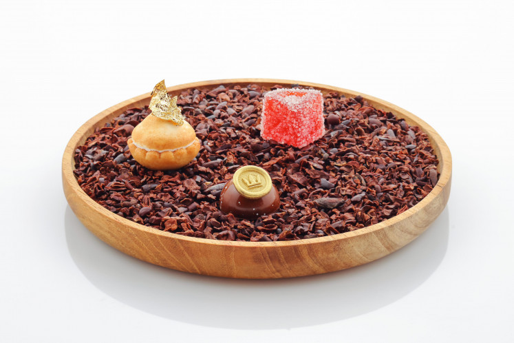 Three petits four—Lemon Meringue Pie, Blood Orange Fruit Pastel and a Coffee & Chocolate Bonbon—served on a bed of cocoa nibs to end the meal.