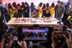 West Java Police spokesperson Sr. Comr. Hendrawan Rochmawan (center) and Director of General Crime Investigation Sr. Comr. Surawan (left) speak to the press at West Java Police headquarters in Bandung on July 17, 2025, following the arrest of 13 suspects involved in an alleged human trafficking case. Authorities revealed the suspects trafficked at least 25 babies, mostly to Singapore, through an illegal adoption network.