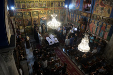 Christian Palestinian mourners attend the funeral ceremony of Saad Salameh and Foumia Ayyad, killed earlier in an Israeli strike that hit the Holy Family church in Gaza City, as Archbishop Alexios of the Saint Porphyrius Church leads the mass on July 17, 2025. An Israeli strike on Gaza's only Catholic church killed three people on July 17. 