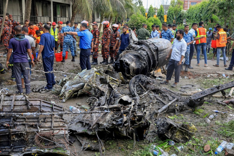 Bangladesh's fire service and security personnel conduct a search and rescue operation after an Air Force training jet crashed into a school in Dhaka on July 21, 2025. A Bangladeshi training fighter jet crashed into a school in the capital Dhaka on July 21, killing at least 19 people and injuring dozens more in the country's deadliest aviation accident in decades.