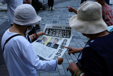 People react as they read a special edition of Yomiuri Shimbun newspaper reporting the tariff deal agreement between US and Japan in Tokyo  on July 23, 2025.