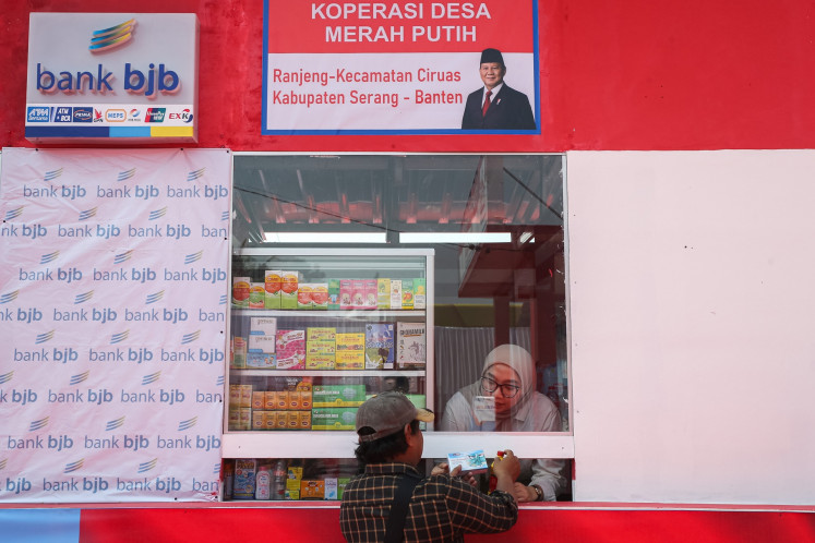 A worker serves a customer at the pharmacy stall during the launch ceremony of a Red and White Cooperative in Serang regency, Banten on July 21, 2025. The cooperative is one of 80,000 sites opened under the Red and White Cooperative initiative launched by President Prabowo Subianto on July 21.