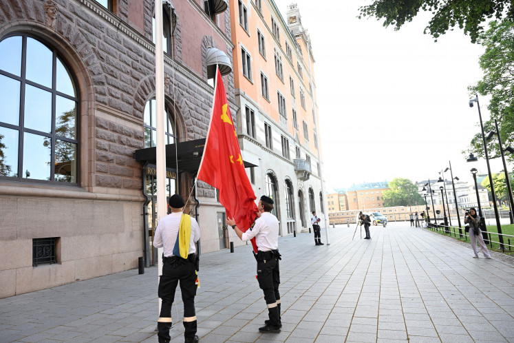Security officials raise the Chinese flag outside of Sweden's government offices “Rosenbad“ in Stockholm on July 28, 2025, ahead of the trade talks between China and USA.