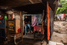Ratnaningsih, 35, lives alone in her shack, Pejagalan, Jakarta, August 2016. She was born under the toll road but her parents went back to Lamongan, East Java, since the eviction. When business at Kalijodo was robust, she sold snacks and food at her stall. 