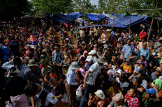 People who fled their homes near the border between Cambodia and Thailand gather at a food distribution site on the grounds of a pagoda in Oddar Meanchey province on July 28, 2025. 