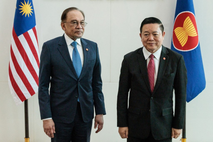 Malaysia's Prime Minister Anwar Ibrahim (left) and Secretary General of the Association of Southeast Asian Nations (ASEAN) Kao Kim Hourn pose at the ASEAN Secretariat in Jakarta on July 29, 2025. 