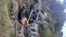 Safety first: A worker and three Indonesian Military (TNI) soldiers take a rest on Monday while installing stairs at Pelawangan Sembalun leading to Segara Anak Lake on the slope of Mount Rinjani in Sembalun, East Lombok, West Nusa Tenggara. The Mount Rinjani National Park is repairing the tracks and will close the volcano from Aug. 1-10.