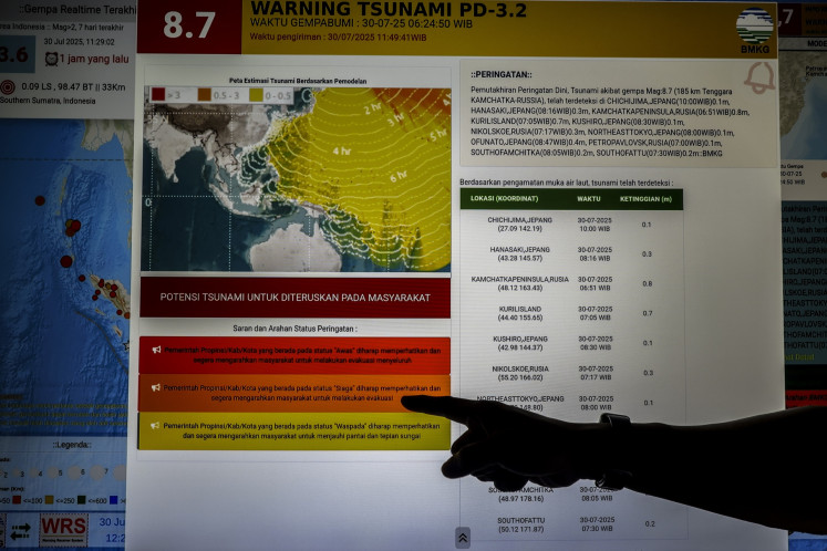 On alert: A Meteorology, Climatology and Geophysics Agency (BMKG) official points at the epicenter of an 8.8-magnitude earthquake in Kamchatka, Russia, on Wednesday at the agency station office in Ternate, North Maluku. Indonesian authorities issued a tsunami advisory status on Wednesday after projections showed that the quake in Russia could trigger waves capable of reaching the eastern part of Indonesia.