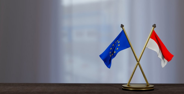 An illustration of Indonesian and European Union flags on a table 