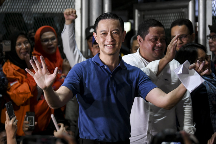 Former trade minister Thomas Lembong waves his hands as he exits Cipinang Penitentiary in Jakarta on August 1, 2025. President Prabowo Subianto has granted him abolition, a form of clemency that eliminates a legal prosecution.  Thomas was sentenced to four and a half years in prison two weeks ago, in a trial that had been largely considered politically motivated.