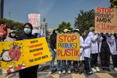Activists from the Ecological Observation and Wetlands Conservation (ECOTON) and students hold posters reading “Stop the production of plastic packaging“ during a protest near an installation in the shape of a heart and lungs damaged by exposure to microplastics waste to raise awareness of the impact of single-use plastics on the environment and human health in Surabaya, East Java on July 16, 2025.