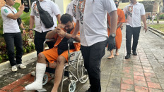 Violence and deceit: Tajaddin Hajiyep (seated) and Evgeniy Viktorovich Pak (rear, second right) are paraded in front of the media on Thursday during a press conference in Kuta, Bali. Hajiyep and Pak were arrested for committing two robberies targeting money changers in Bali.