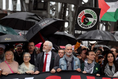 Demonstrators including WikiLeaks founder Julian Assange (3rd left, wearing red tie) cross the Sydney Harbour Bridge during a pro-Palestinian rally against Israel's actions and the ongoing food shortages in the Gaza Strip, in Sydney on August 3, 2025. 