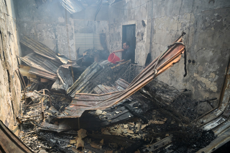 Devastating blaze: A resident helps put out a fire on July 21 in Duri Utara, Tambora, West Jakarta. The West Jakarta Fire and Rescue Agency deployed 29 fire trucks and 145 personnel to tackle the fire that engulfed a 9,000-square-meter residential area.