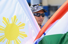 An Indian Navy sailor stands with Philippine and Indian flags at the international port of Manila on August 1, 2025, ahead of joint patrols between the two navies in the South China Sea. 
