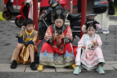 Past meets present: A family dressed in imperial-style costumes waits outside the Forbidden City on July 20 in Beijing.