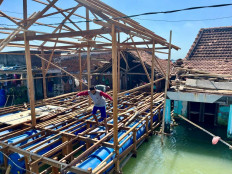 Two men work on the flooring of a floating house in Timbulsloko village, Sayung district, Demak regency, Central Java, on Saturday, Aug. 2, 2025. The Central Java provincial administration is building floating houses for villagers affected by tidal floods.