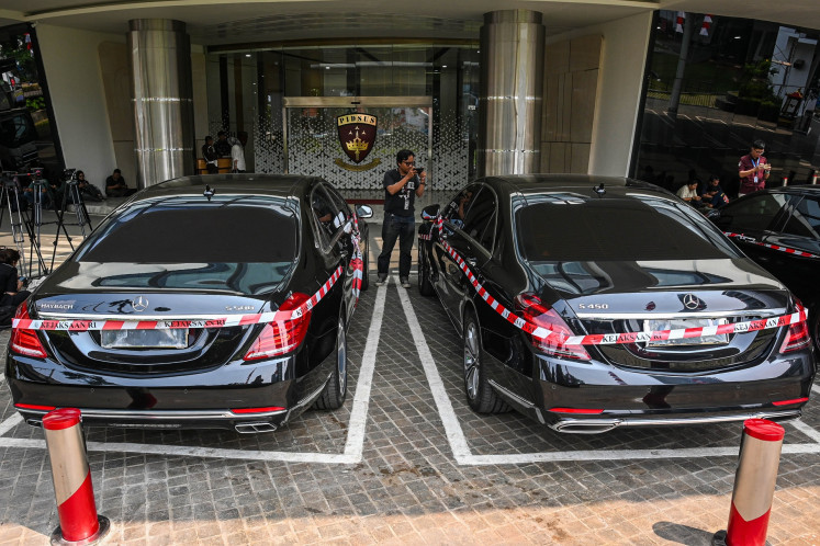 A man takes a photo on Aug. 5, 2025 of cars owned by oil tycoon Riza Chalid seized by the the Office of the Assistant Attorney General for Extraordinary Crimes (Jampidsus) at the Attorney General's Office (AGO) headquarters in Jakarta. AGO investigators seized five cars and cash as evidence against Riza, who has been named as a suspect in a corruption case pertaining to fuel imports by state energy firm Pertamina.