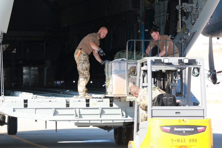 A German Air Force (Luftwaffe) airman uses a forklift to load a humanitarian aid pallet into the cargo bay of an A400M Atlas military transport aircraft on the tarmac at King Abdullah II airbase in Zarqa, Jordan, on August 5, 2025, before taking off for a humanitarian aid airdrop mission over the Gaza Strip. Israel has been fighting Palestinian militant group Hamas in Gaza for 22 months and imposed a total blockade on March 2, partially lifted in May to allow a US-backed private agency to open food distribution centers.