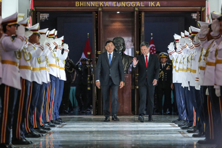 Defense Minister Sjafrie Sjamsoeddin (left) and Singaporean Defense Minister Chan Chun Sing (right) walk out of the meeting room following a bilateral meeting at the Defense Ministry in Jakarta on Aug. 5, 2025. The Indonesian Defense Ministry received a courtesy visit from the Singaporean minister to discuss military cooperation, including joint exercises and plans for soldier exchange programs for military education purposes.