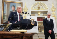 US President Donald Trump speaks behind an engraved glass disc presented to him by Apple CEO Tim Cook during an event in the Oval Office of the White House on August 6, 2025 in Washington, DC. Apple Inc. 