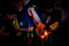 Protesters burn an effigy of United States President Donald Trump during a protest near the US Consulate General in Rio de Janeiro on Aug. 1, 2025, after Washington imposed trade tariffs and sanctions on Brazil.