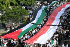 Participants carry the flags of Palestine (left) and Indonesia on July 27, 2025, during a pro-Palestine rally held by civic organizations and the Banda Aceh administration in Banda Aceh, Aceh.