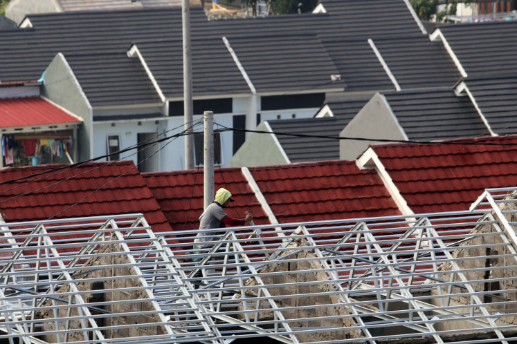 A worker installs roof rafters on Aug. 6, 2025, at a subsidized housing estate in Bogor, West Java.