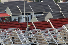 Lofty ambitions: A worker works on the roof of an under-construction house in a subsidized housing estate on Aug. 6 in Bogor, West Java.