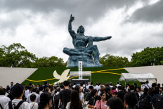 People stand in front of the Peace statue after the annual memorial ceremony for the victims at the Peace Park in Nagasaki, Japan on Aug. 9, 2025, to mark the 80th anniversary of the atomic bombing during World War II.