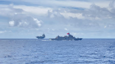 The Indonesian Navy's KRI Raden Eddy Martadinata 331 (foreground) passes in front of the Royal Navy's aircraft carrier HMS Prince of Wales on July 31 during a passing exercise along the Indonesian Sea Lane of Communications (ALKI) III in the Banda Sea, southwest of Buru Island. The HMS Prince of Wales is leading a multinational carrier strike group for a deployment around the Indo-Pacific region.