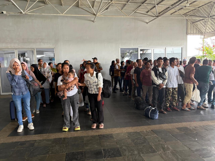 A group of repatriated Indonesians, including 71 migrant workers, wait in line for the next leg of their journey on Aug. 9, 2025, after arriving at Batam Center International Ferry Port in the Riau Islands from Johor Bahru, Malaysia.