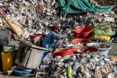 An Afghan worker sorts recyclable plastic collected at a recycling yard on the outskirts of Kabul on August 5, 2025.