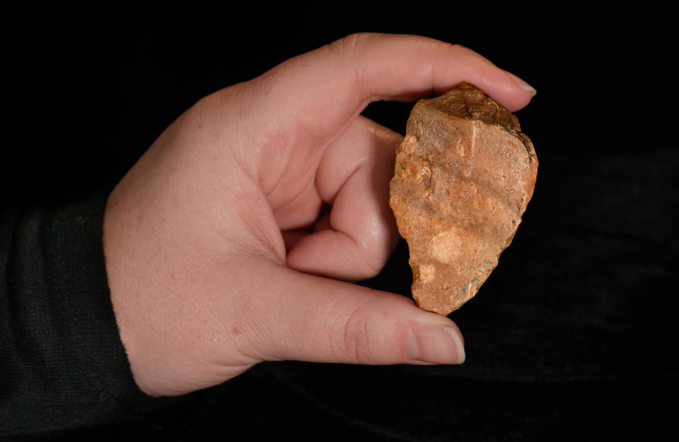 An archaeologist shows one of the ancient stone tools uncovered at the Calio site in Soppeng regency, South Sulawesi, in this undated photo. The tools they found dated back at least 1.04 million years, suggesting that prehistoric humans once lived on Sulawesi.