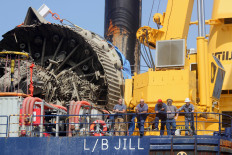 Workers stand on the SEACOR Marine 335 Class L/B Jill liftboat as they transport debris from a SpaceX rocket, which exploded during a routine ground test at Starbase, the company's launch facility on the south Texas coast near the Mexican border, offshore from Matamoros, Mexico on July 20, 2025.